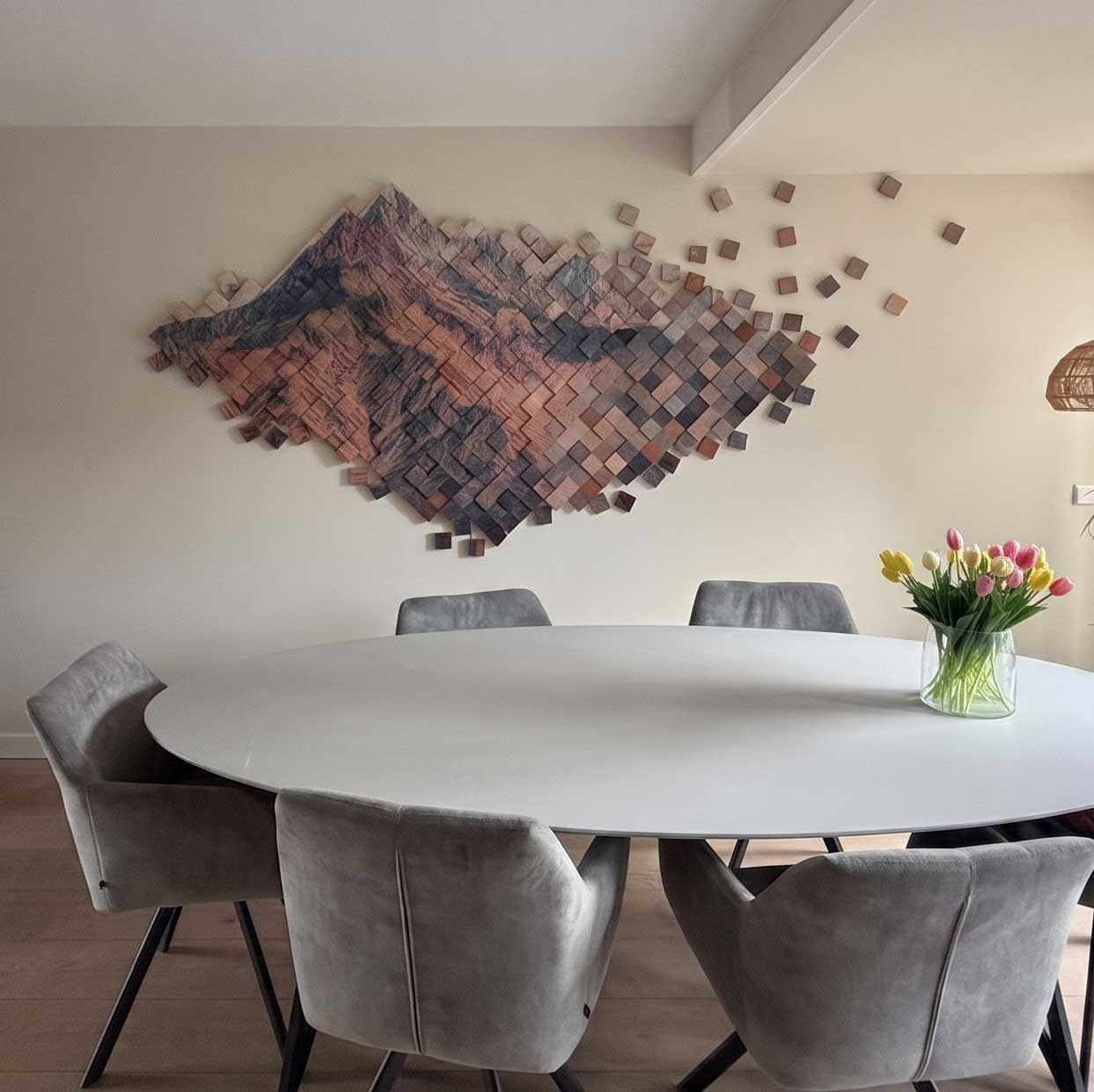 Houten 3D wandwerk met berglandschap, geplaatst boven een eettafel - opdracht gemaakt door Paula Ackermann
